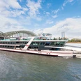 MS RheinMagie Modern excursion boat RheinMagie on the Rhine in front of a large arched bridge in Cologne