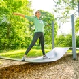 Frau trainiert auf geschwungener Fitnessstation im Eggeland-Park Bad Driburg.