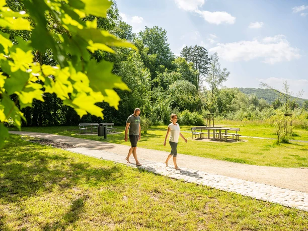 Bad Driburg-Barfußpfad Eggeland-Park-Teutoburger-Wald-Bad-Driburger-Touristik-GmbH Zwei Personen gehen barfuß über den Barfußpfad im Eggeland-Park Bad Driburg.