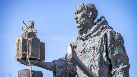 Fritzlar Bonifatius 20230718_NZ64074 (MR) 16zu9 StadtmarketingFritzlar_CC-BY-SA.jpg Auf dem Foto ist das Denkmal des Heiligen Bonifatius zu sehen, einer lebensgroßen Statue des Gründers der Stadt Fritzlar. In der rechten Hand trägt die Statue ein Kirchenmodell und in der linken Hand eine Axt.