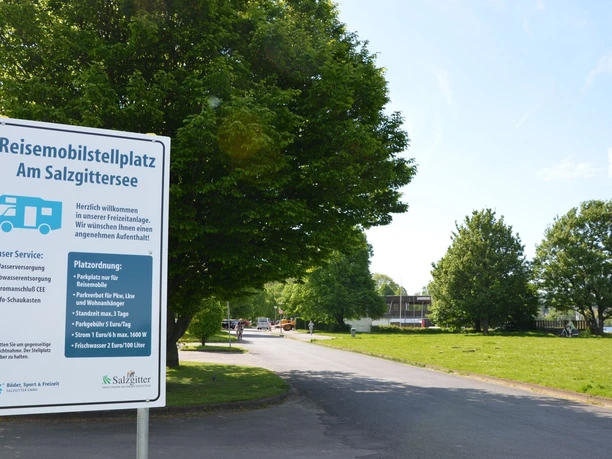 Wohnmobilstellplatz_Salzgittersee_HD_16zu9.JPG Weißes Hinweisschild für den Reisemobilstellplatz am Salzgittersee an einer Zufahrtsstraße.