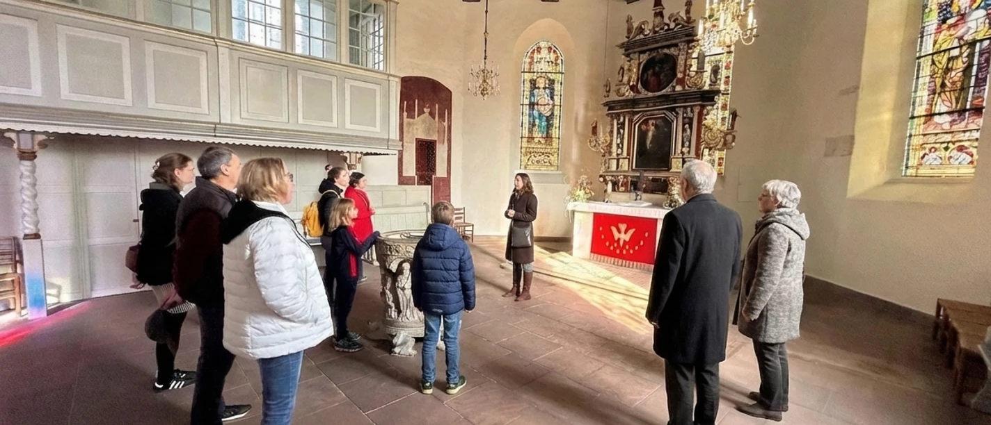 Gästeführung vor dem Altar der Kirche Eine Besuchergruppe bei einer Führung im historischen Altarraum der St.-Ulrichs-Kirche.