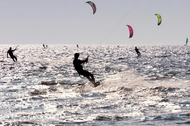 Kitesurfer in der Nordsee beim Kite Spot Upleward Silhouetten von Kitesurfern auf dem glitzernden Wasser am Kite Spot Upleward.