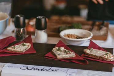 Schmalzbrot Kulinarische Meile Drei herzhafte Schmalzbrote mit frischer Garnitur angerichtet auf einem Holzbrett.