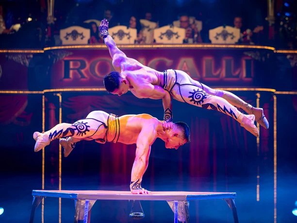 Duo Vitalys - Hand auf Hand, Circus-Theater Roncalli Zwei Artisten balancieren kraftvoll übereinander auf einer Bühne im Roncalli-Zirkus.