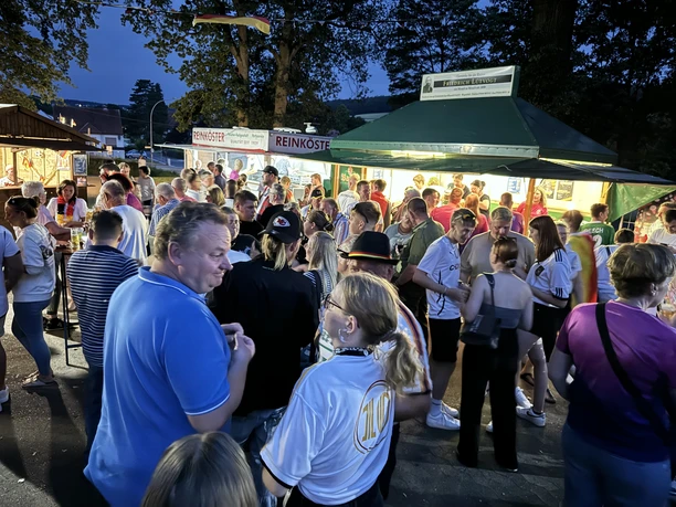 WM Studio Menschenmenge beim Public Viewing vor Imbissständen am Abend in Börninghausen