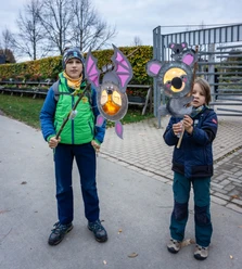 Zwei Kinder halten leuchtende Tierlaternen beim Laternenumzug im Bürgerpark.