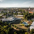 Platsch Oschatz - Freizeitbad in der Leipzig Region Die Luftaufnahme zeigt das Freizeitbad Platsch mit Saunadorf in Oschatz sowie das Stadtpanorama mit den markanten Kirchtürmen der St.-Aegidien-Kirche im Hintergrund.