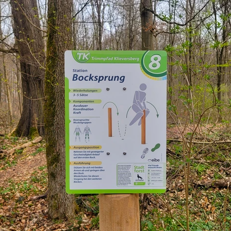 Trimmpfad - Infotafel an Station.jpg Grüne Infotafel im Wald für Station 8 Bocksprung am Trimmpfad Klieversberg.