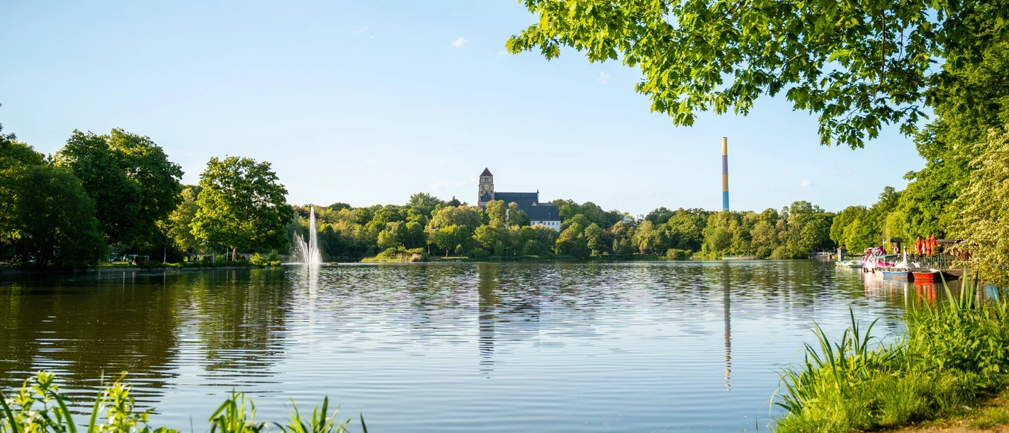 Schlossteich Chemnitz mit bunter Esse (Lulatsch) im Hintergrund