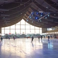 Eislaufen_Salzgittersee (4)_HD_16zu9.jpg Zahlreiche Menschen laufen in der hellen Eissporthalle mit Holzdecke Schlittschuh.