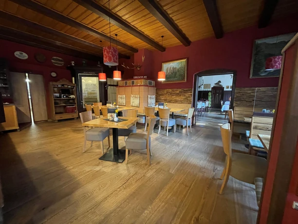 De eetkamer aan de voorkant met rustieke houten tafels en een open haard.