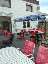 Ristorante Pizzeria Da Giuseppe Außenbereich des Ristorante Da Giuseppe mit Tischen, roten Stühlen und Sonnenschirmen