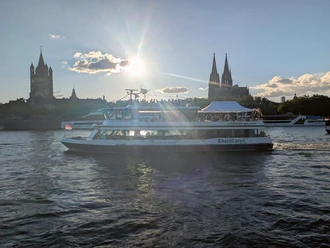 Die Kölntourist Personenschiffahrt auf dem Rhein in Köln Personenschiff auf dem Rhein vor Kölner Dom im Gegenlicht der tiefen Sonne