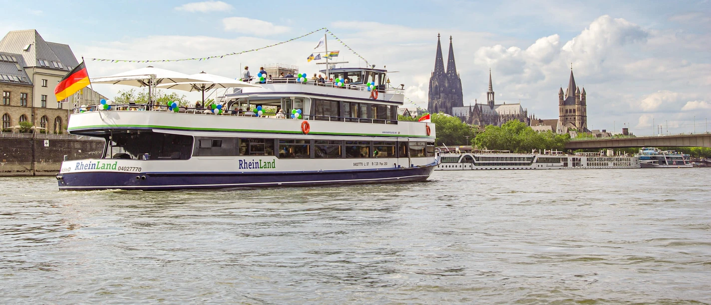 Die Kölntourist Personenschiffahrt auf dem Rhein in Köln Ausflugsschiff auf dem Rhein vor Kölner Skyline mit Kathedrale und Uferbebauung