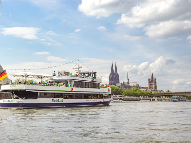 Die Kölntourist Personenschiffahrt auf dem Rhein in Köln Ausflugsschiff auf dem Rhein vor Kölner Skyline mit Kathedrale und Uferbebauung