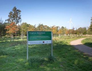 N9027 (c) Helmut Gross_Erlebnis Bremerhaven_WEB.jpg Schild am Bürgerhain Bremerhaven mit vielen Bäumen im Hintergrund