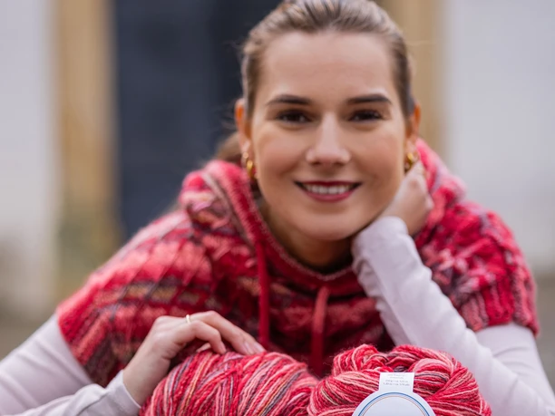 pullunder_wolle_alva.jpg Frau mit selbstgestricktem Pullunder und Wollknäuel auf einem Tisch