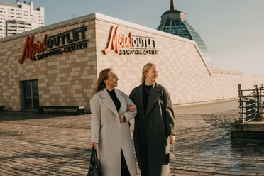 Zwei lächelnde Frauen beim Einkaufsbummel vor dem Mein Outlet & Shopping-Center in Bremerhaven