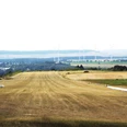 Flugplatz_Schaeferstuhl_Salzgitter_HD_16zu9.jpg Segelflugzeug und Motorflieger auf einer Graspiste vor weiter Landschaft mit Windrädern.