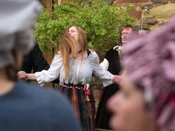 Lebendige Stadtführung Sie sehen eine sehr lebendig und emotional dargestellte Szene der historischen Theaterstadtführung, vor der imposanten Kulisse.
