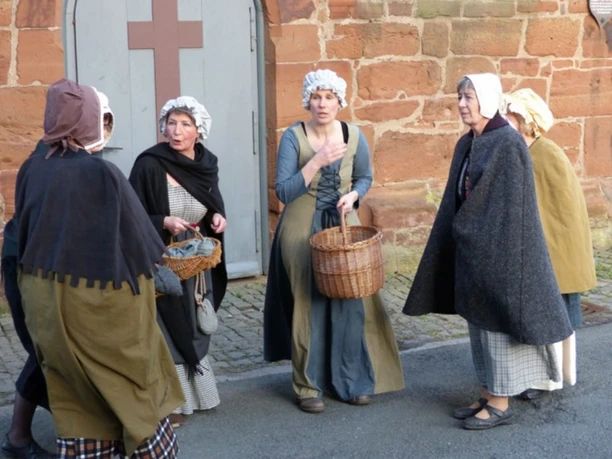 Habt Ihr schön gehört ... Sie sehen eine Gruppe von fünf Frauen in historischen Gewändern des späten Mittelalters, wie sie eine mittelalterliche Scene aus Frankenberg Eder nachspielen.