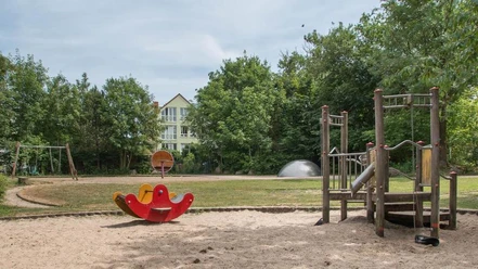 IMG_7397_WEB.jpg Spielplatz Krumme Straße mit Wippe und Klettergerüst auf dem Sandbereich und einer Schaukel und großer Rasenfläche