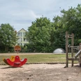 IMG_7397_WEB.jpg Spielplatz Krumme Straße mit Wippe und Klettergerüst auf dem Sandbereich und einer Schaukel und großer Rasenfläche