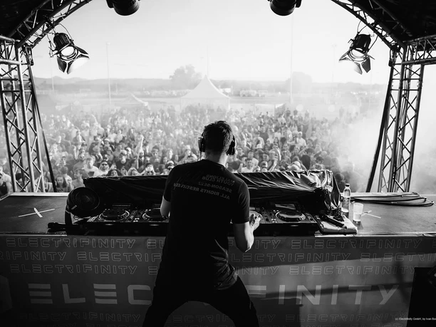 Electrifinity-Festival-IvanBortondello.jpg DJ am Mischpult auf großer Bühne vor Festivalbesuchern