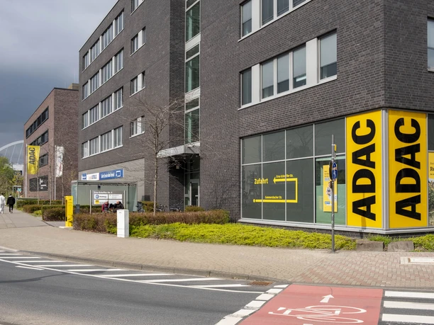 ADAC Radservice Station Moderne ADAC-Station an breiter Straße mit gelbem Servicepunkt und Radweg im urbanen Umfeld