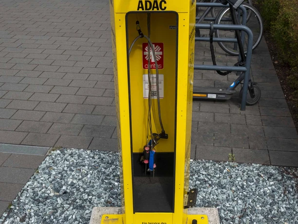 ADAC Radservice Station Gelbe ADAC-Radservicestation mit Werkzeugen neben Fahrradständern vor einem Gebäude