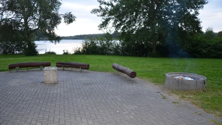 Grillplatz_SchutzhuetteamSee (2)_HD_16zu9.JPG Gepflasterter Grillplatz mit Holzbänken und rauchender Feuerstelle direkt am Salzgittersee.