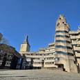 Rathaus Bensberg Rathaus Bensberg: markanter Betonbau mit geschwungenen Formen neben historischem Steinturm unter klarem Himmel.