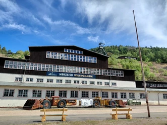 Erzaufbereitung Weltkulturerbe Rammelsberg Gebäude der Erzaufbereitung am Rammelsberg mit alten Bergbaufahrzeugen davor.