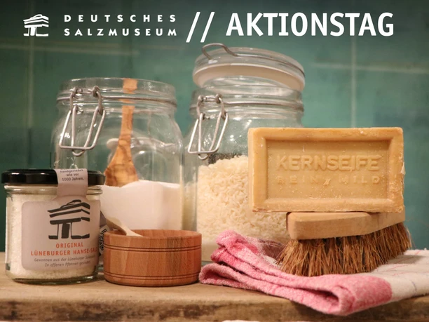 Aktionstag "Blitzblank & brillant günstig" im Salzmuseum Verschiedene selbsthergestellte Waschmittel, Kernseife, Salz und Putzutensilien stehen auf einem Tisch.