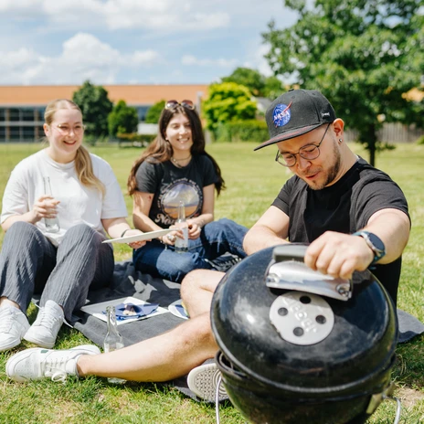 Grillen.jpg Drei Personen grillen im Allerpark auf der Wiese.