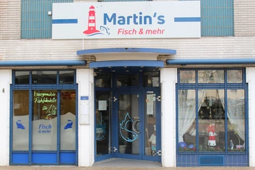 Martins Fisch und mehr IMG_8196 (c) Jasmin Emilia Meyer_Erlebnis Bremerhaven_WEB.jpg Außenansicht des Restaurants Martin's Fisch & mehr mit blauem Eingang und Leuchtturm-Schild.