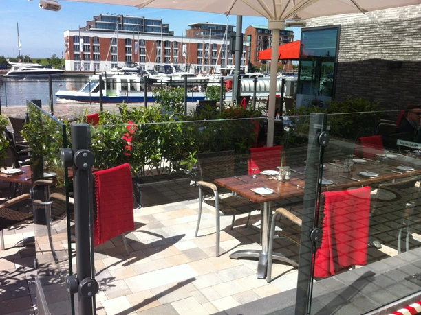 PIER 6 - Sonnenterrasse mit Blick auf die Marina Neuer Hafen (c) Steffen Heumann_Erlebnis Bremerhaven.jpg Sonnige Restaurantterrasse mit gedeckten Tischen und Blick auf Schiffe im Neuen Hafen.