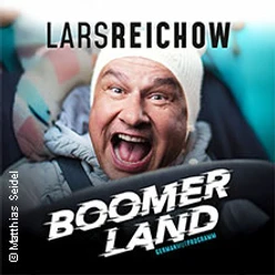 Lachender Mann in Wintermütze vor blauem Hintergrund mit dem Schriftzug Boomerland