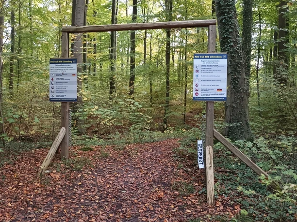 Mountainbike-Parcours Lichtenberg(15)_HD_16zu9.jpg Startbereich des Mountainbike-Parcours im Wald mit Holztor und Infotafeln.