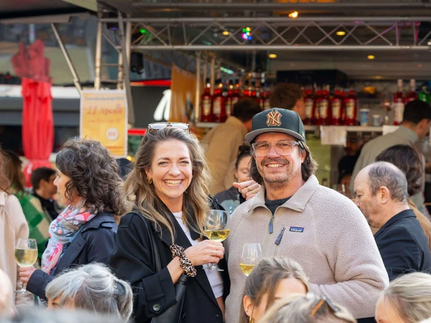 After-work market on Chlodwigplatz People at the after-work market stand close together holding glasses of white wine