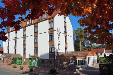 Mittwald Hotel Außenansicht des Mittwald Hotels mit rotem Dach und begrüntem Eingangsbereich