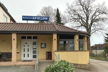Restaurant Apollon Helles Gebäude des griechischen Restaurants Apollon mit Eingang, Rampe und Wintergarten.