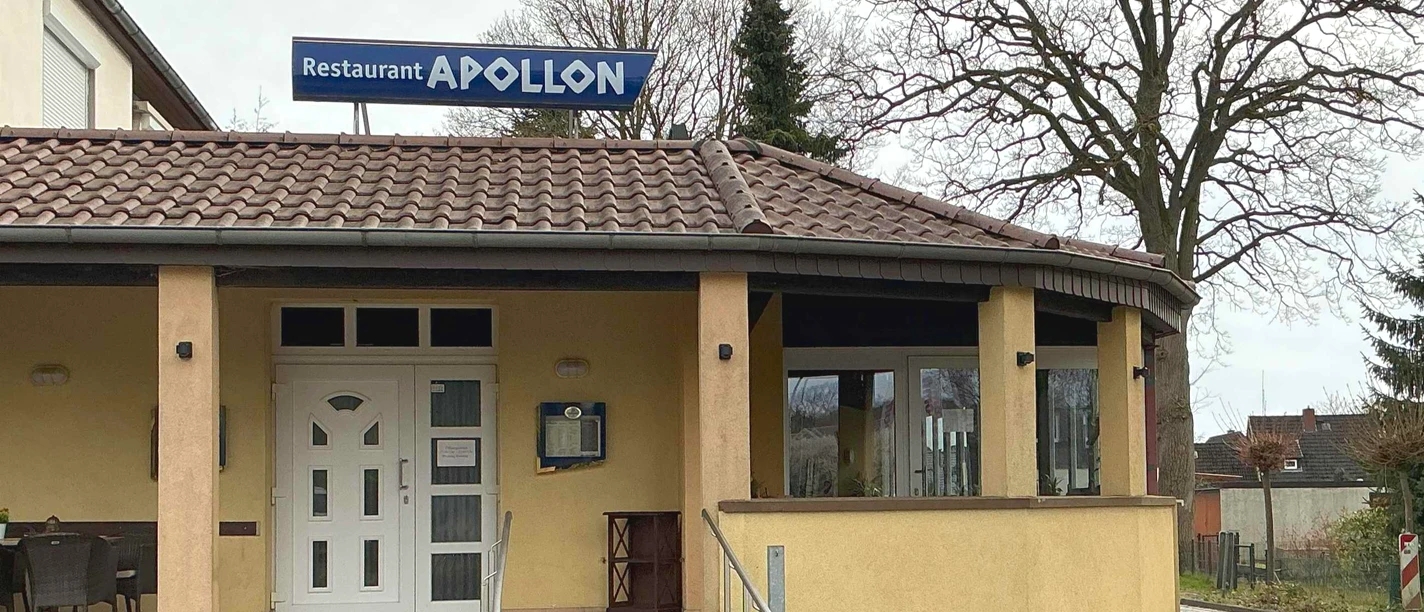 Restaurant Apollon Helles Gebäude des griechischen Restaurants Apollon mit Eingang, Rampe und Wintergarten.