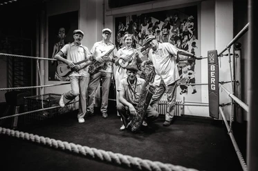 The Ukelites mit Instrumenten im Boxring - schwarzweiß Foto