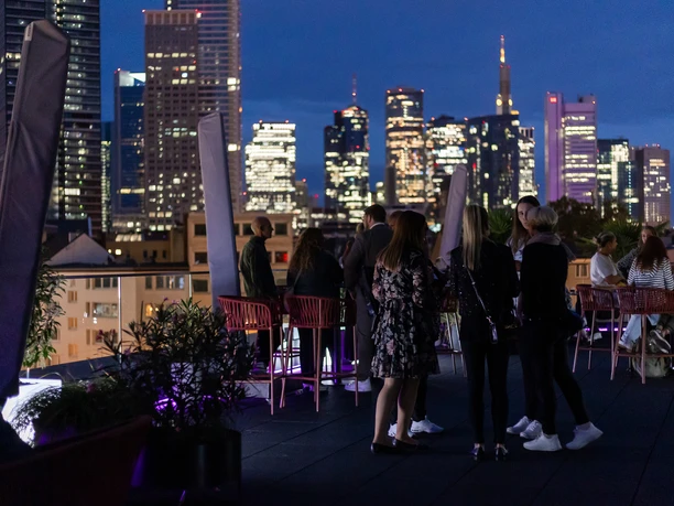 OAKS Bar im NH Collection Frankfurt Spin - Dachterrasse Gäste auf Dachterrasse mit Blick auf Frankfurter Skyline