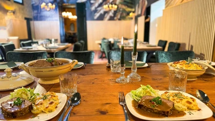 Meatloaf with baked potato and salad Table set with meatloaf, baked potatoes, salad and lighted candles in the restaurant
