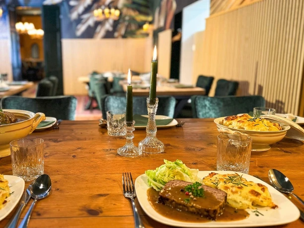 Meatloaf with baked potato and salad Table set with meatloaf, baked potatoes, salad and lighted candles in the restaurant