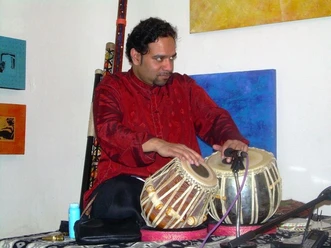 Arup Sen Gupta_ Hindustani Classical Music (c) Atelier 21_Arup Sen Gupta.jpg Ein Mann spielt sitzend auf einem indischen Instrument.