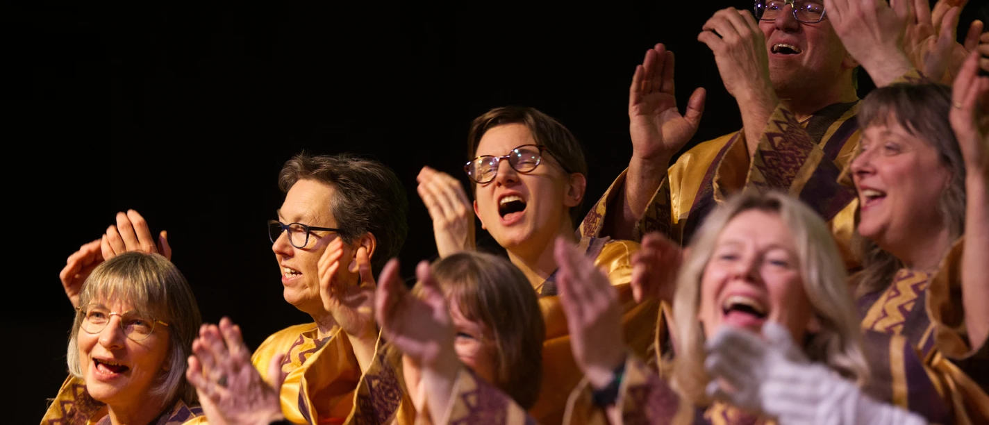 Gospelchor Begeisterte Chorsänger in goldenen Gewändern klatschen und singen voller Freude beim Gospelkonzert.